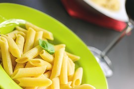 Green plate with pasta and wine