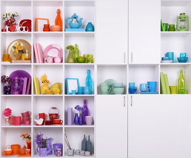 Colorful tableware on display in a white cupboard