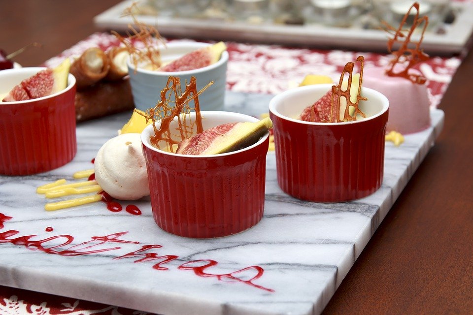 Marble slab with Christmas treats served in colorful bowls